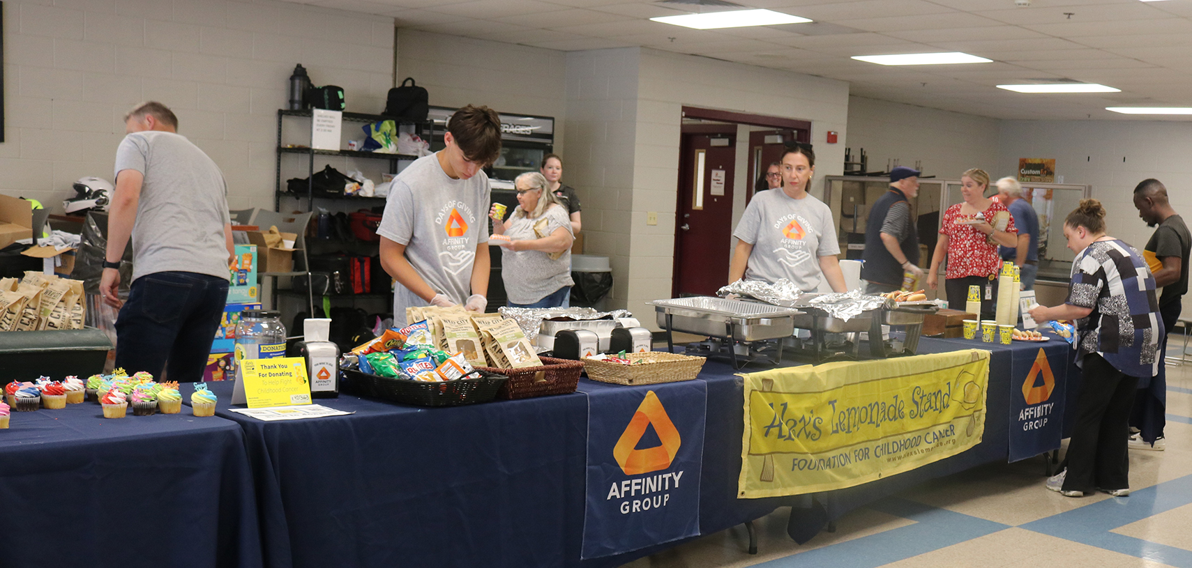 Two men smiling in blue shirts.